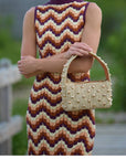 Raffia top handle bag with gold studs styled on a model – The Lachlan
