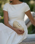 Woman holding heart-shaped shell clasp on The Love Heart Clutch