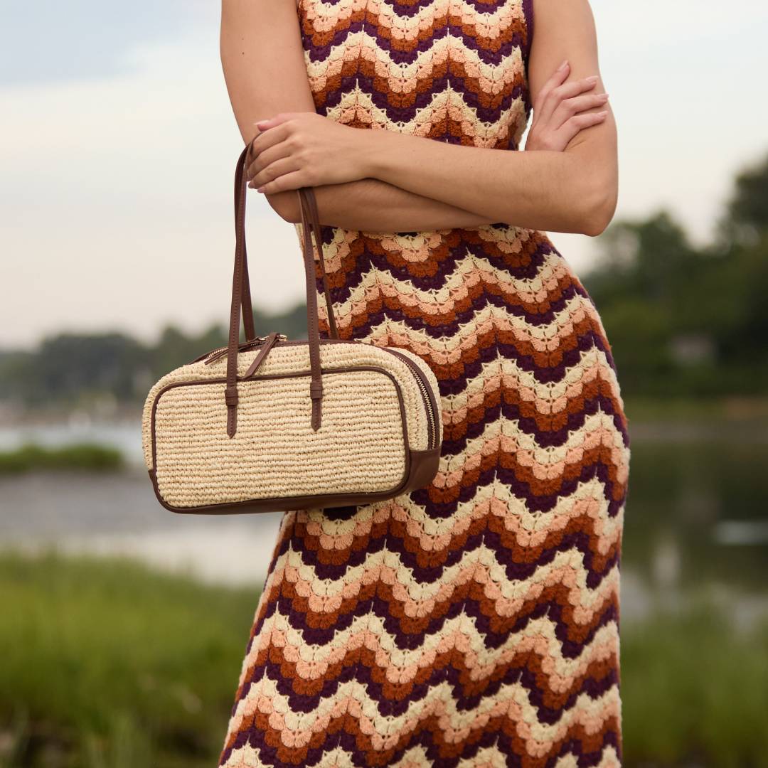 Woven raffia bowler bag with leather trim styled on a model – The Bowler Bag