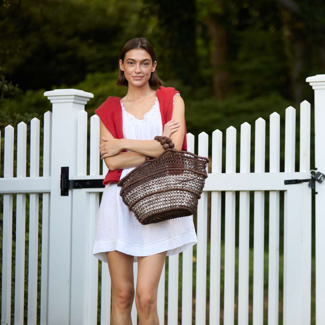 Handwoven straw tote bag styled on a model – The Comporta Tote