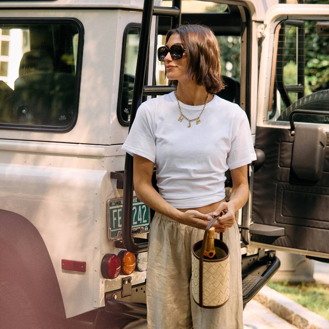 Woven straw cylinder bag with leather trim  styled on a model – The Cylinder