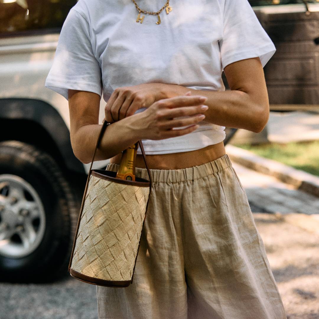 Woven straw cylinder bag styled on a model – The Cylinder