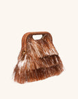 Tinsel fringe detail with raffia-wrapped handle