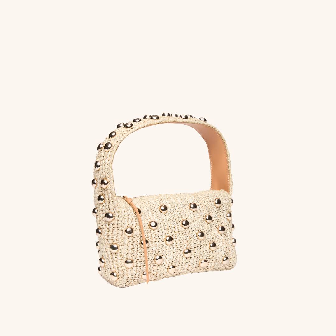 Quarter view of The Lachlan raffia bag with gold stud accents