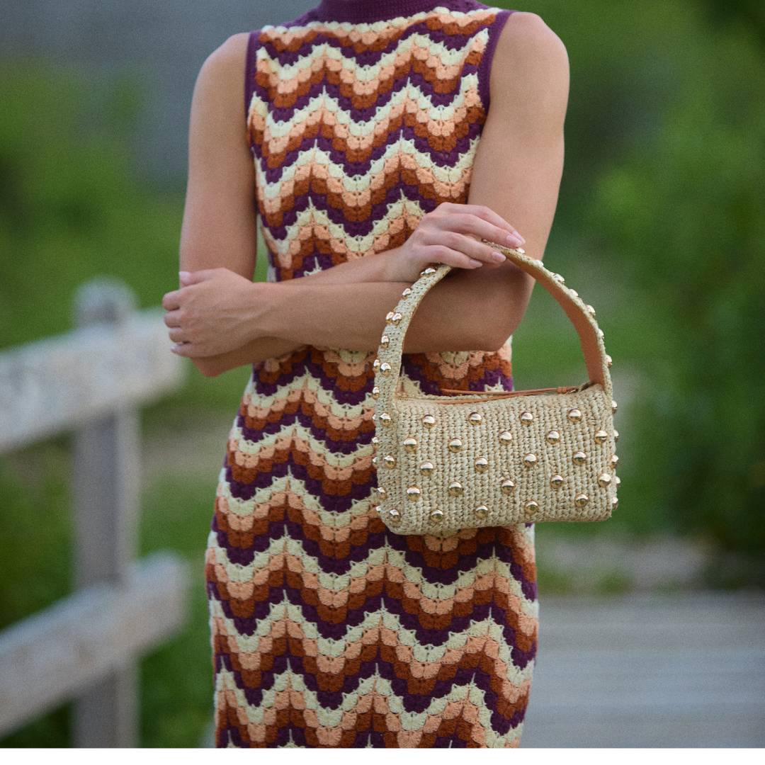 Raffia top handle bag with gold studs styled on a model – The Lachlan