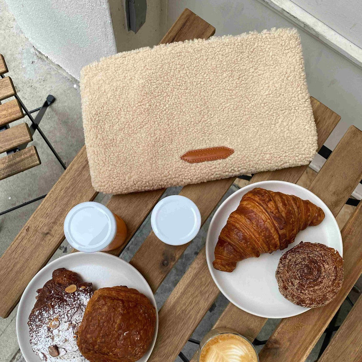 The Teddy Clutch sherpa pouch on table