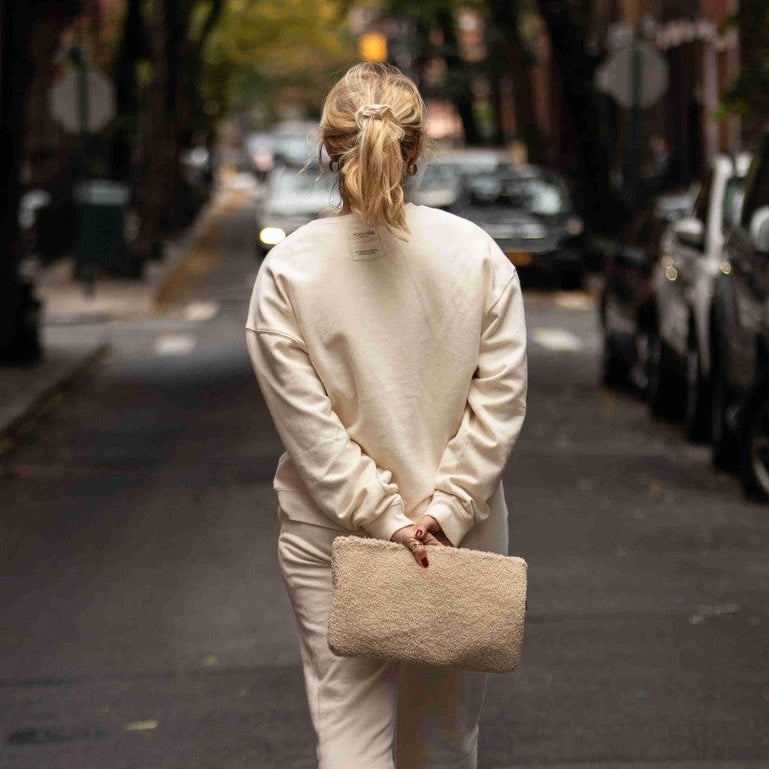 The Teddy Clutch sherpa pouch held in hand